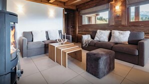 A cozy living room with a fireplace, two sofas, a coffee table, and a view of the outdoors.