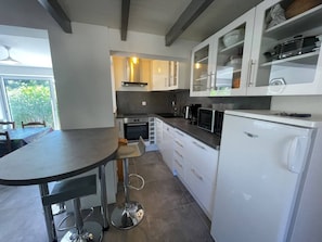A modern kitchen with white cabinets, a black countertop, and stainless steel appliances.