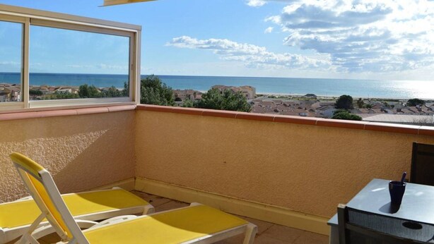 A balcony with a view of the sea, yellow chairs, and a table with a cup. - 3-room villa with air conditioning, parking, and pets allowed in Saint-Pierre-la-Mer (Fleury-Saint-Pierre-la-Mer)