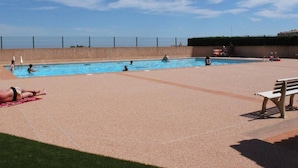 A swimming pool with a clear sky, a bench, and a fence in the background. - Cozy Studio w/ Mezzanine, Terrace, Pool & Parking - Near Beach and Town Center (Fleury-Saint-Pierre-la-Mer)