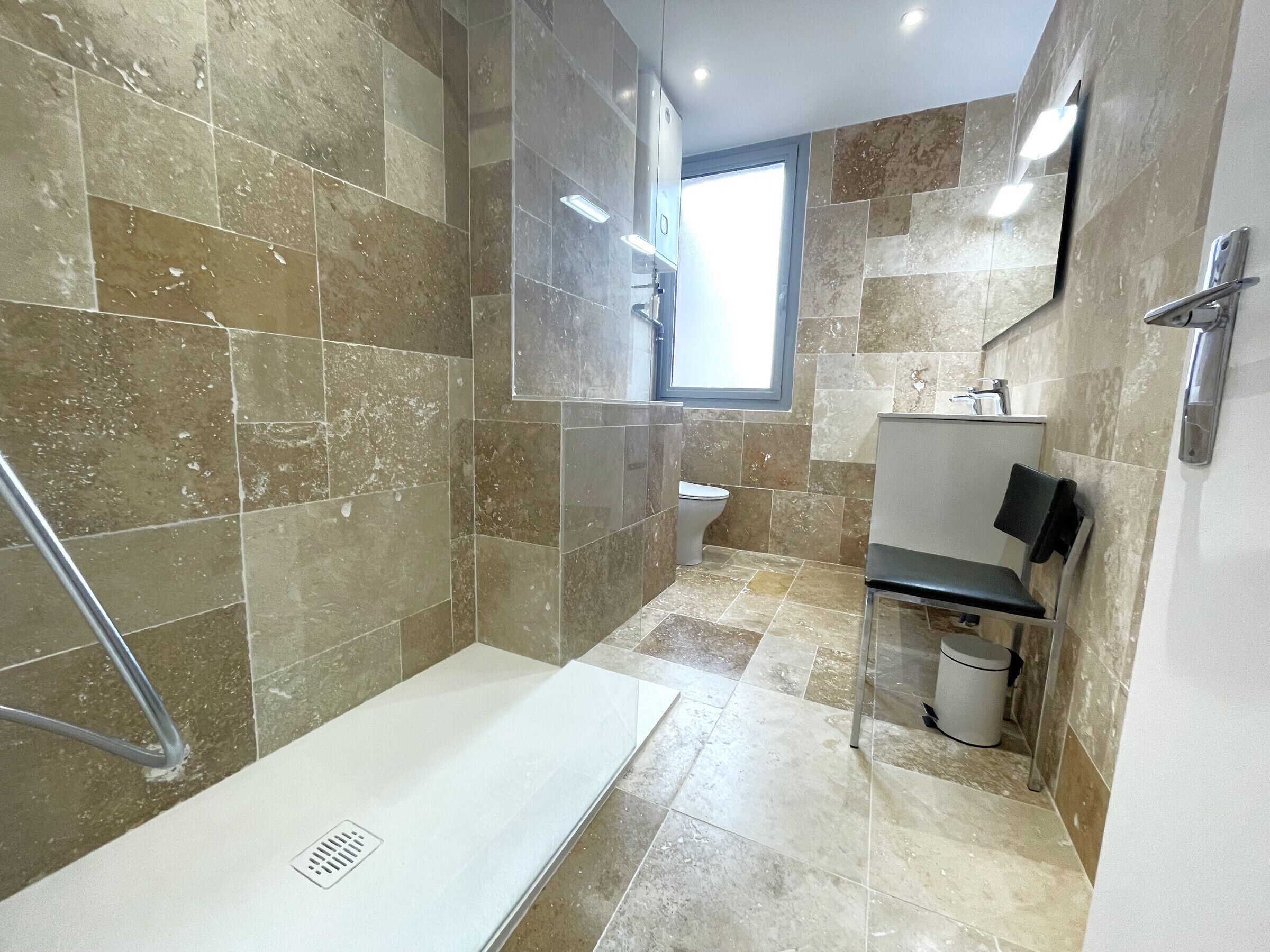Une salle de bain moderne avec une zone de douche, des toilettes et un lavabo.