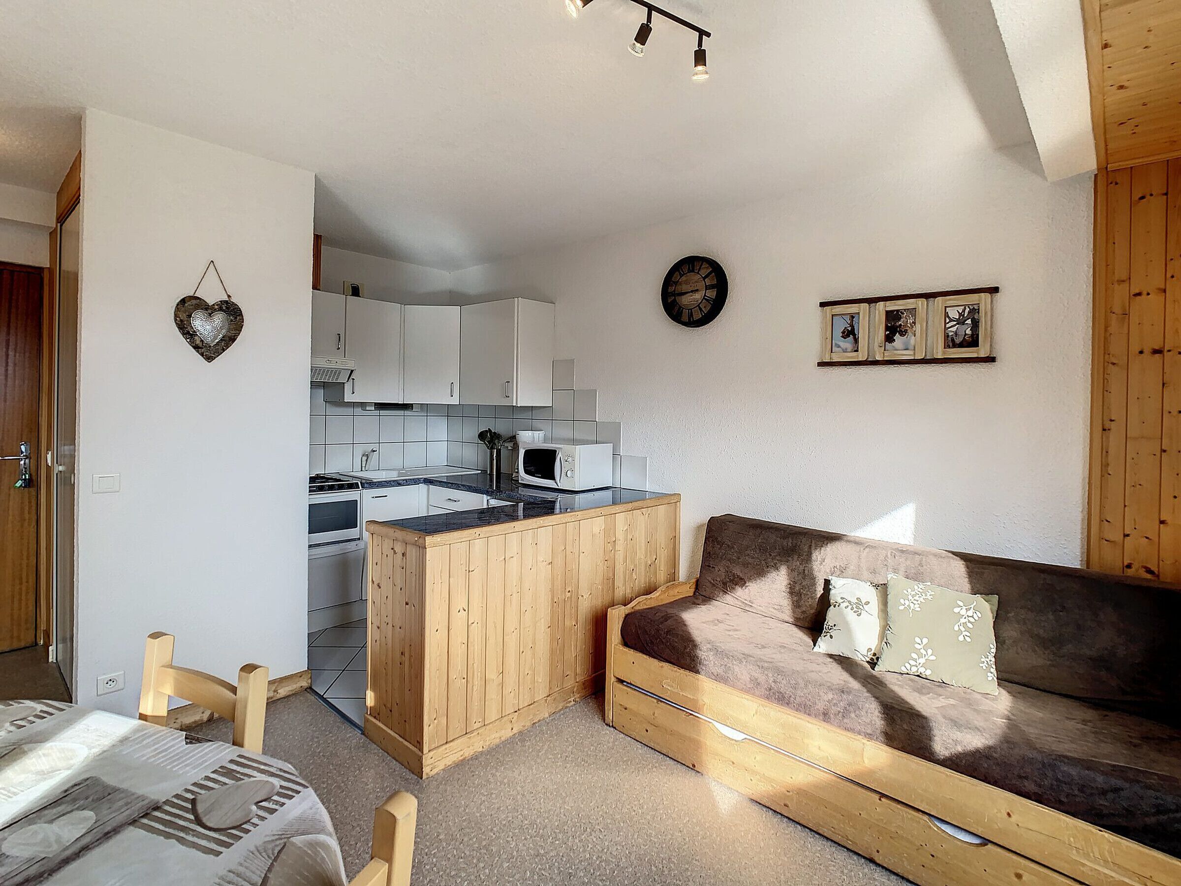A compact living space with a kitchenette, a sofa, and a dining area.