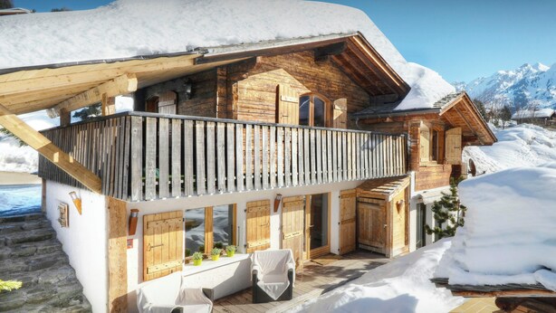 A wooden chalet with a balcony, stone steps, and a snowy landscape. - Chalet Le Petit Mazot - romantic break for 4 close to slopes - OVO Network (La Clusaz)