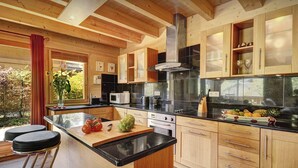 Una cocina moderna con armarios de madera, una isla central y un amplio ventanal.