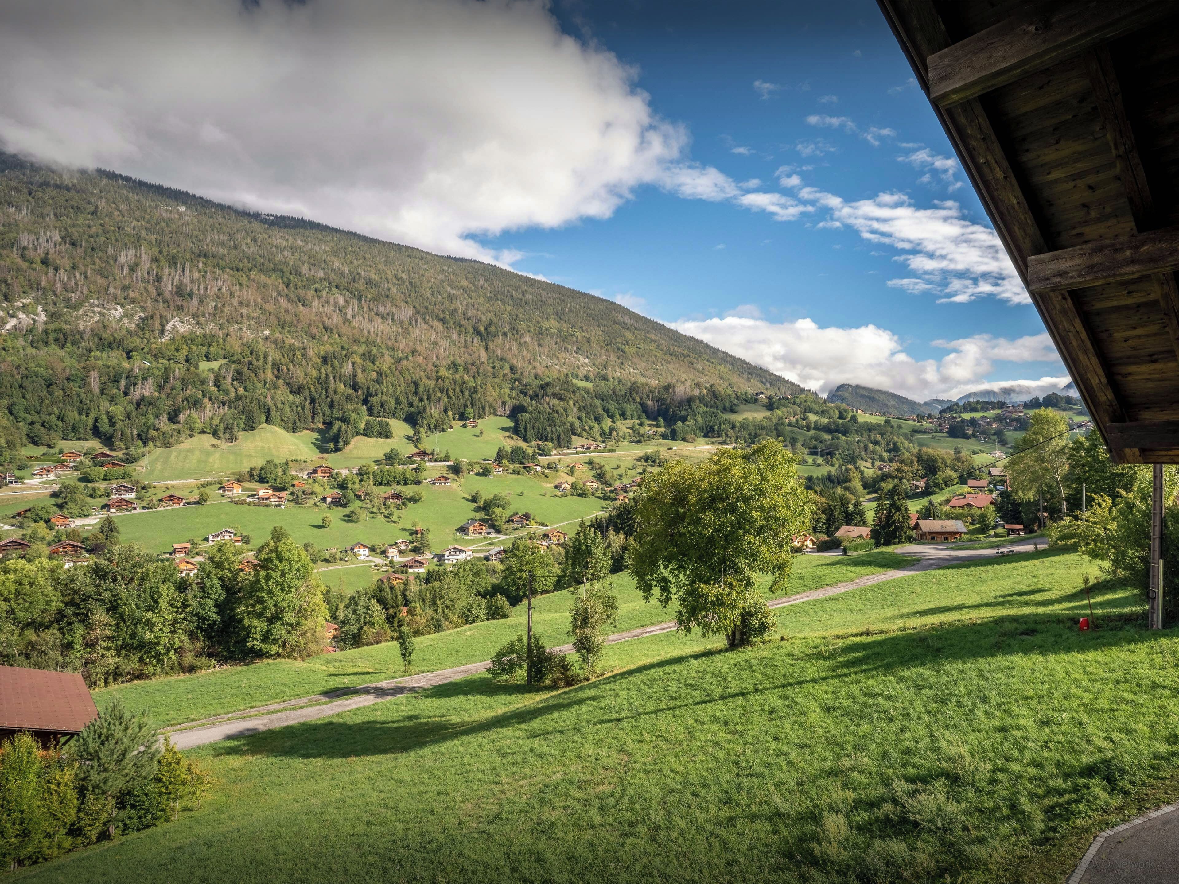 Un paisaje rural con vistas a un valle, casas y una montaña.