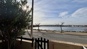A coastal view with a paved walkway, a bench, and a gate. - House 2 rooms, cabin, 6 pers, 400m from beach, parking, terrace (Port-la-Nouvelle)