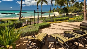 A beach with lounge chairs and a view of the ocean.
