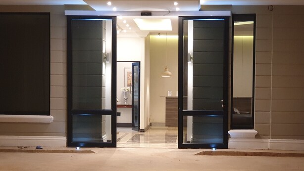 Eine Hotelhalle mit modernem Design, inklusive Glastür-Eingang, einer Rezeption und einem gut beleuchteten Innenraum.