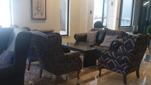 Ein modernes Wohnzimmer mit Marmorboden, Ledersofas und einem Couchtisch.