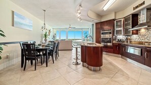 A modern kitchen with dark wood cabinets, stainless steel appliances, and a central island.