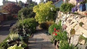 Ein Gartenweg mit verschiedenen Blumentöpfen und einer Steinmauer.