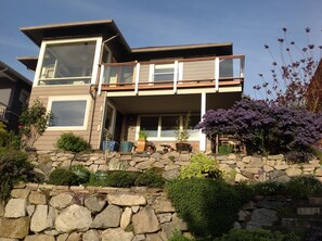 A modern two-story house with a stone retaining wall, a balcony, and various potted plants. - Olympia View Queen Anne Craftsmen  (Seattle)