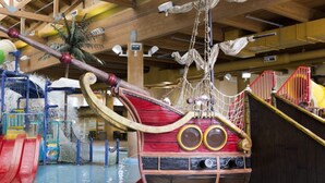 Een speelplaats met water, glijbanen en een piratenschip.