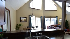 Een keuken met een donker aanrecht, twee spoelbakken en een hangende lamp.