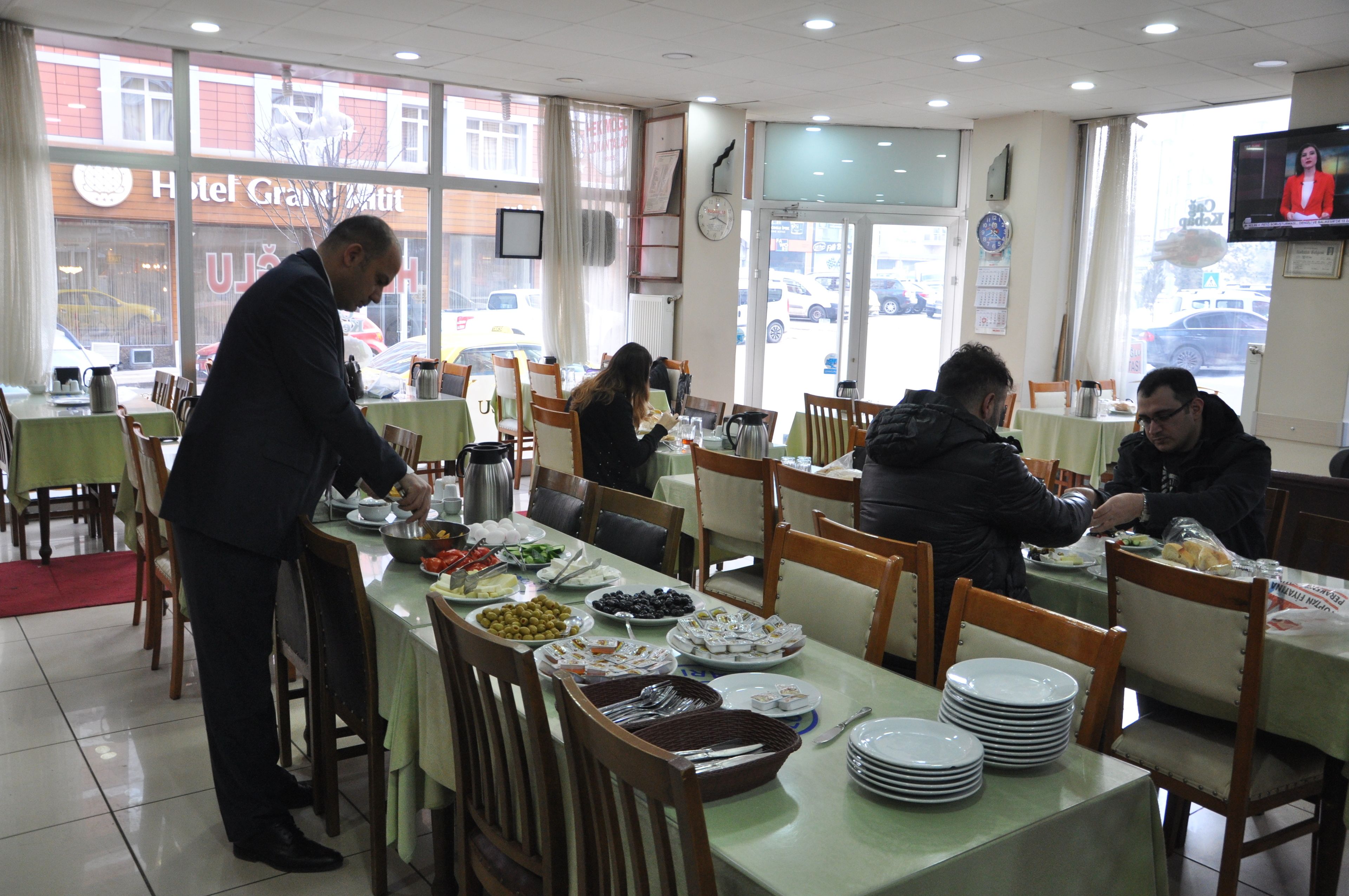 Un restaurant amb diverses taules, un sistema de menjar a discrecció i vista al carrer.