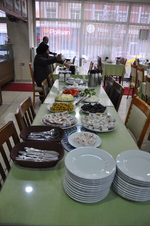A buffet setup with various food items and utensils.