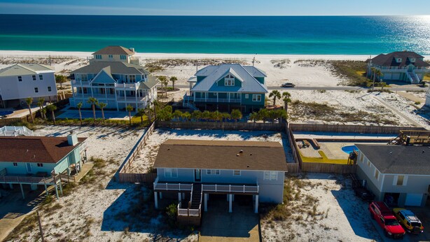 A coastal residential area with beachfront properties, including houses with balconies and a swimming pool.
