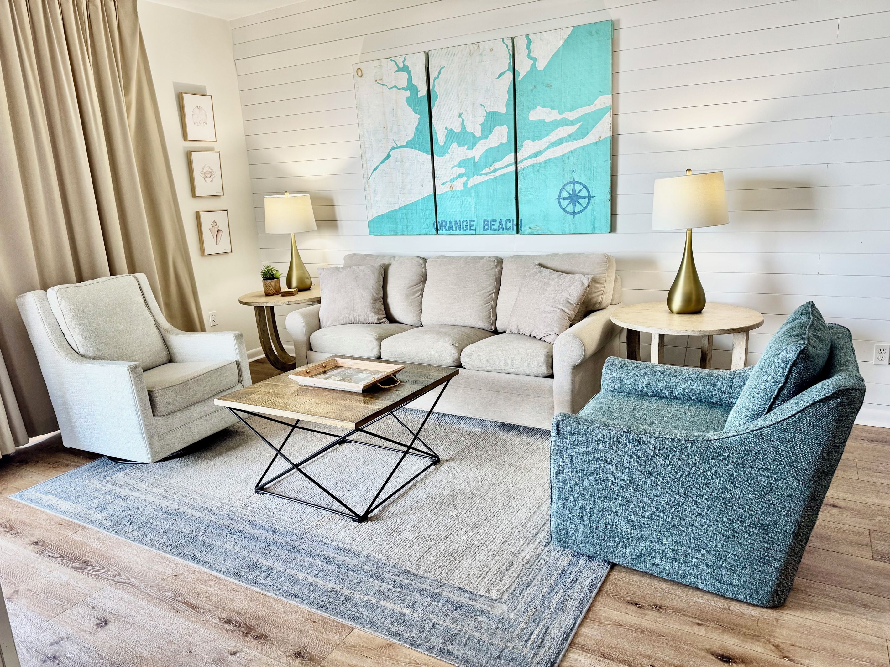 Ein Wohnzimmer mit einer Couch, Sesseln, einem Couchtisch und einer Karte an der Wand.