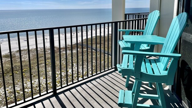 Un balcon avec vue sur la plage et l’océan.