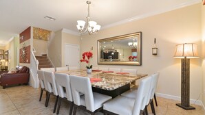 A dining area with a large marble table, white chairs, a chandelier, and a large mirror on the wall. - ⭐⭐⭐⭐⭐ChampionsGate, 9 Bed Luxury Exec Villa, Sleeps 30, West Facing Pool & Spa (Davenport)