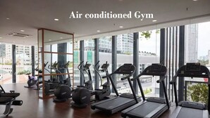 An air-conditioned gym with treadmills, elliptical machines, and weight equipment. - The Landmark Penthouse Luxury Condo by Casa Accommodation (George Town)