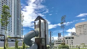 A playground with a slide and climbing structures, surrounded by buildings and greenery. - The Landmark Penthouse Luxury Condo by Casa Accommodation (George Town)