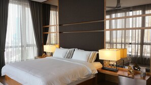A modern hotel room with a large bed, two bedside tables with lamps, a wooden headboard, and large windows with sheer curtains. - The Landmark Penthouse Luxury Condo by Casa Accommodation (George Town)