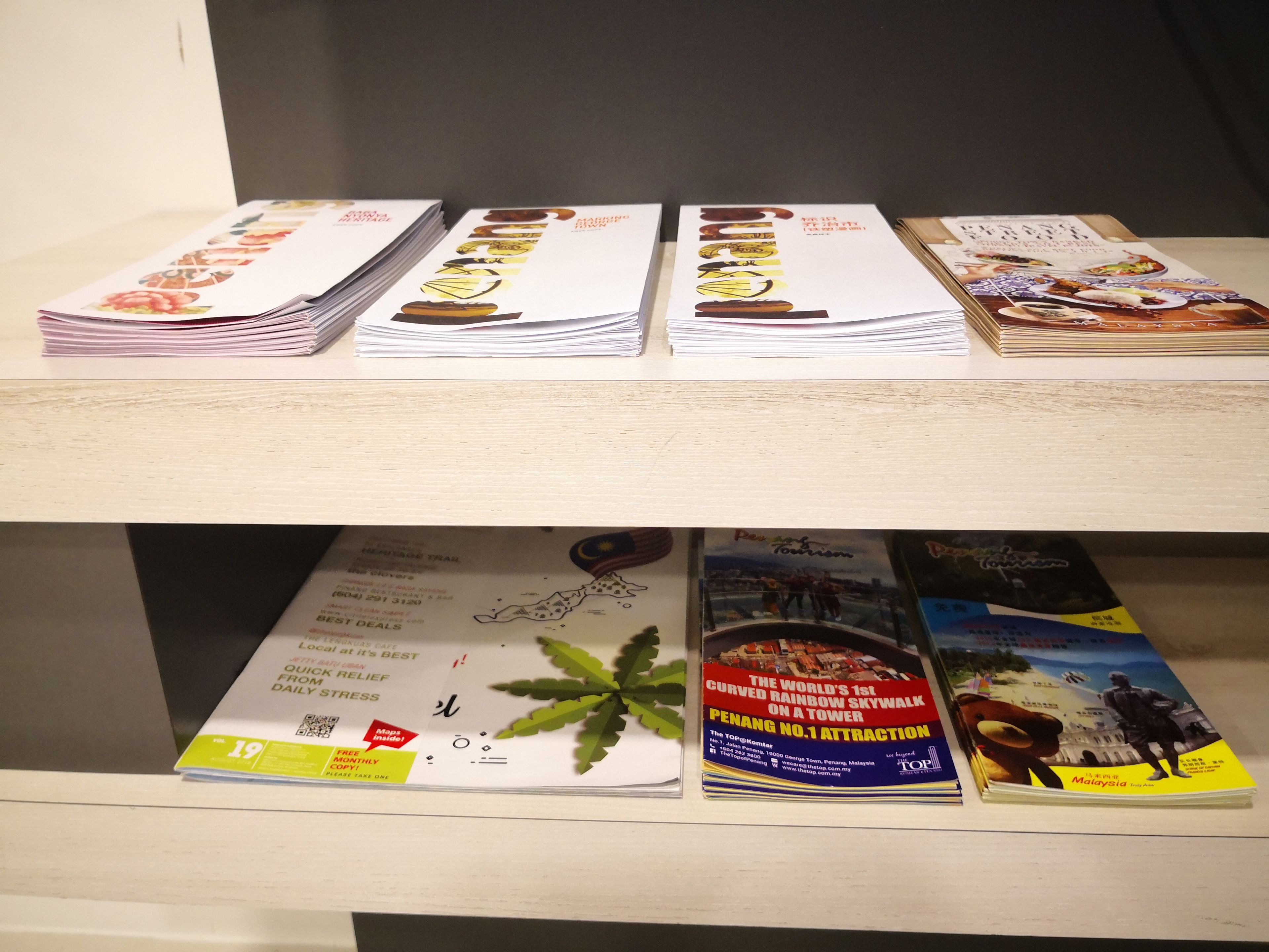 A shelf with stacks of travel brochures.