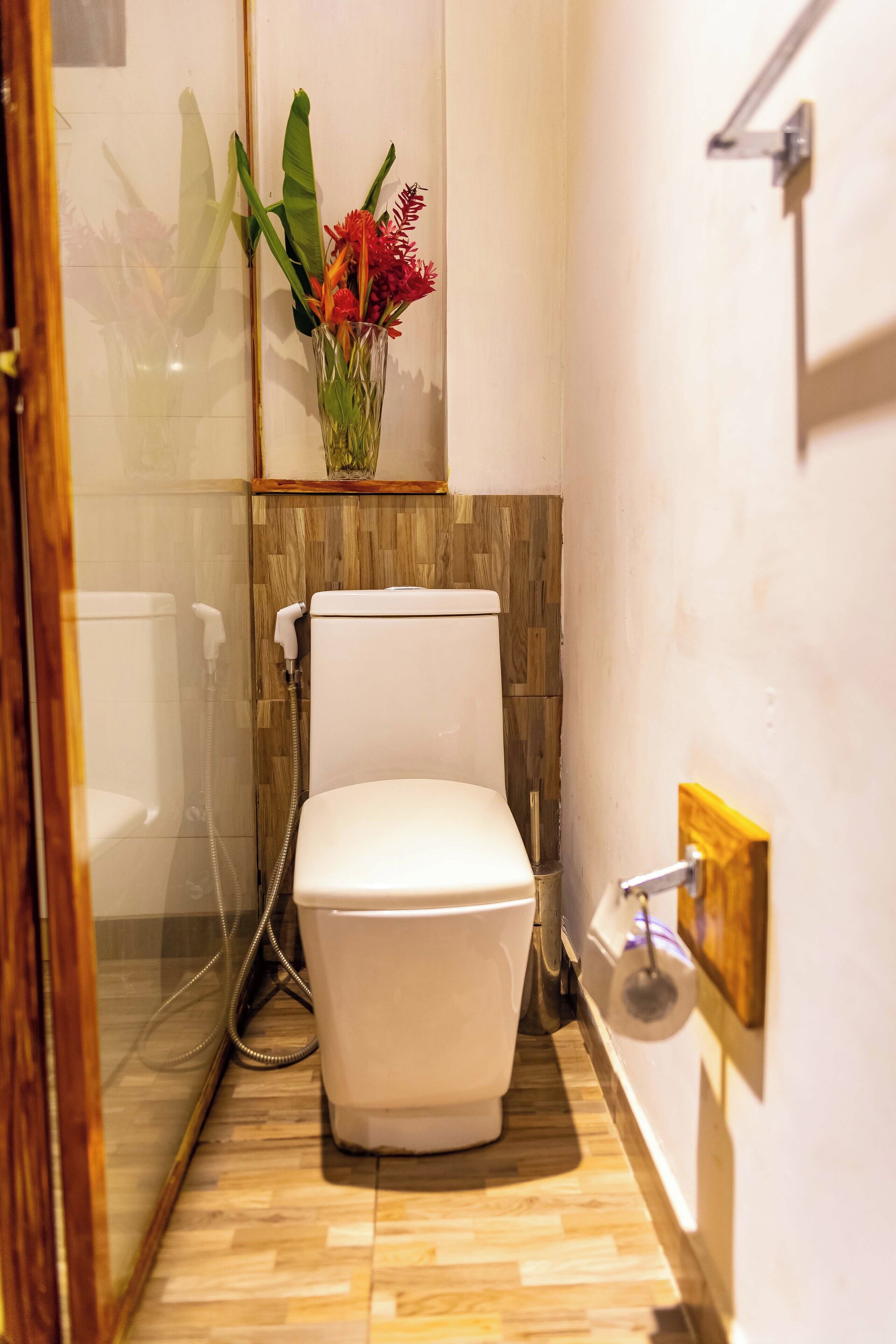 Une salle de bain moderne avec des toilettes, une douche et un plancher en bois.