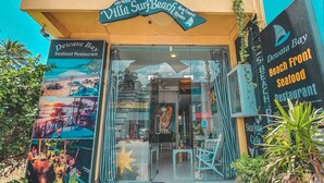A beachfront restaurant named 'Dewata Bay Beach Front Seafood Restaurant' with a clear view of the entrance and seating area. - Villa Surf Beach (Galle)