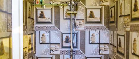 A bathroom with a shower, tiled walls, and framed pictures.