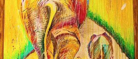 Una pintura abstracta vibrante con una gran figura de elefante y una más pequeña en primer plano, enmarcada en madera.