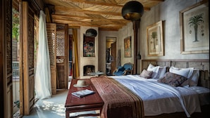Un dormitorio con una cama grande, techo de madera y vista a un jardín.