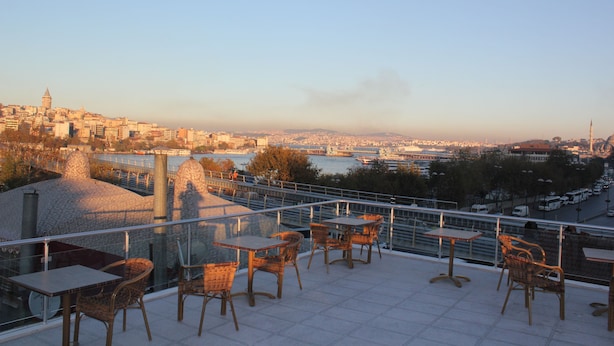 A terrace with tables and chairs overlooking a cityscape with a river and a bridge. - Hotel Terrace Istanbul (Istanbul)