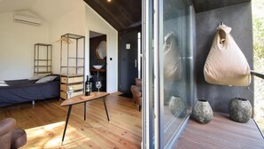 A modern room with a bed, a table with a bottle and wine glass, and a view of the outdoors through a glass door. - Village Cascais Guest House (Cascais)