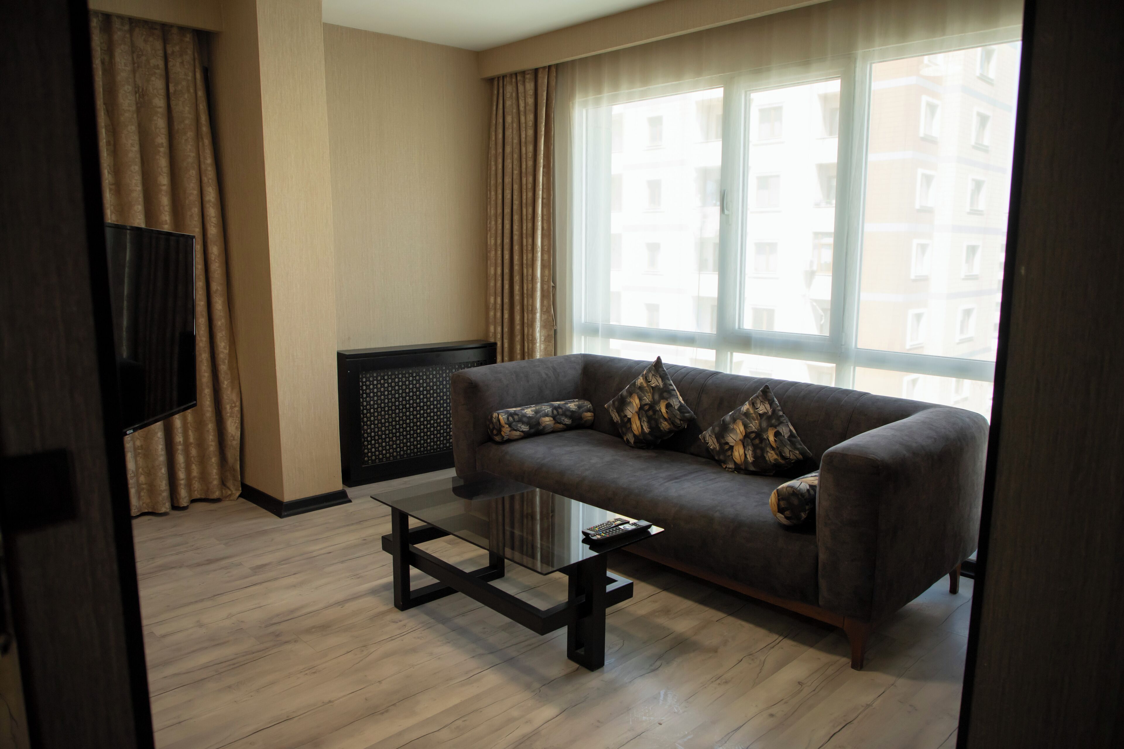 A modern living room with a sofa, a coffee table, and a TV.