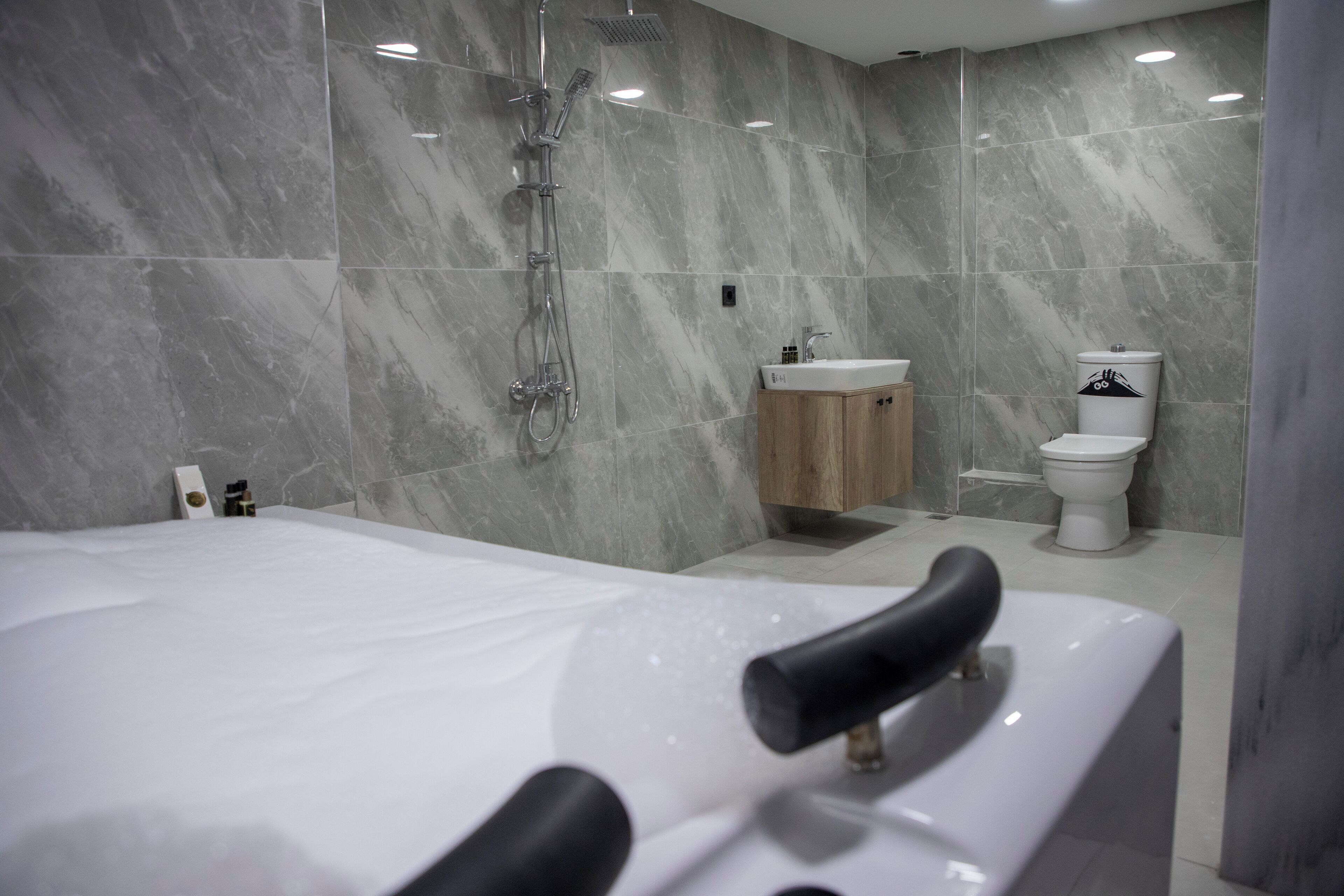 Ein modernes Badezimmer mit einer großen Badewanne, einer Dusche und einem WC.