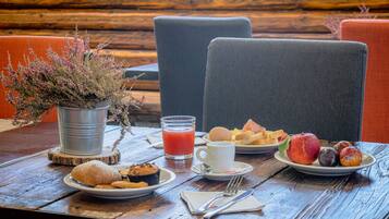 Taula de fusta amb articles per esmorzar, com ara ous, torrades, un muffin i un plat de fruita.