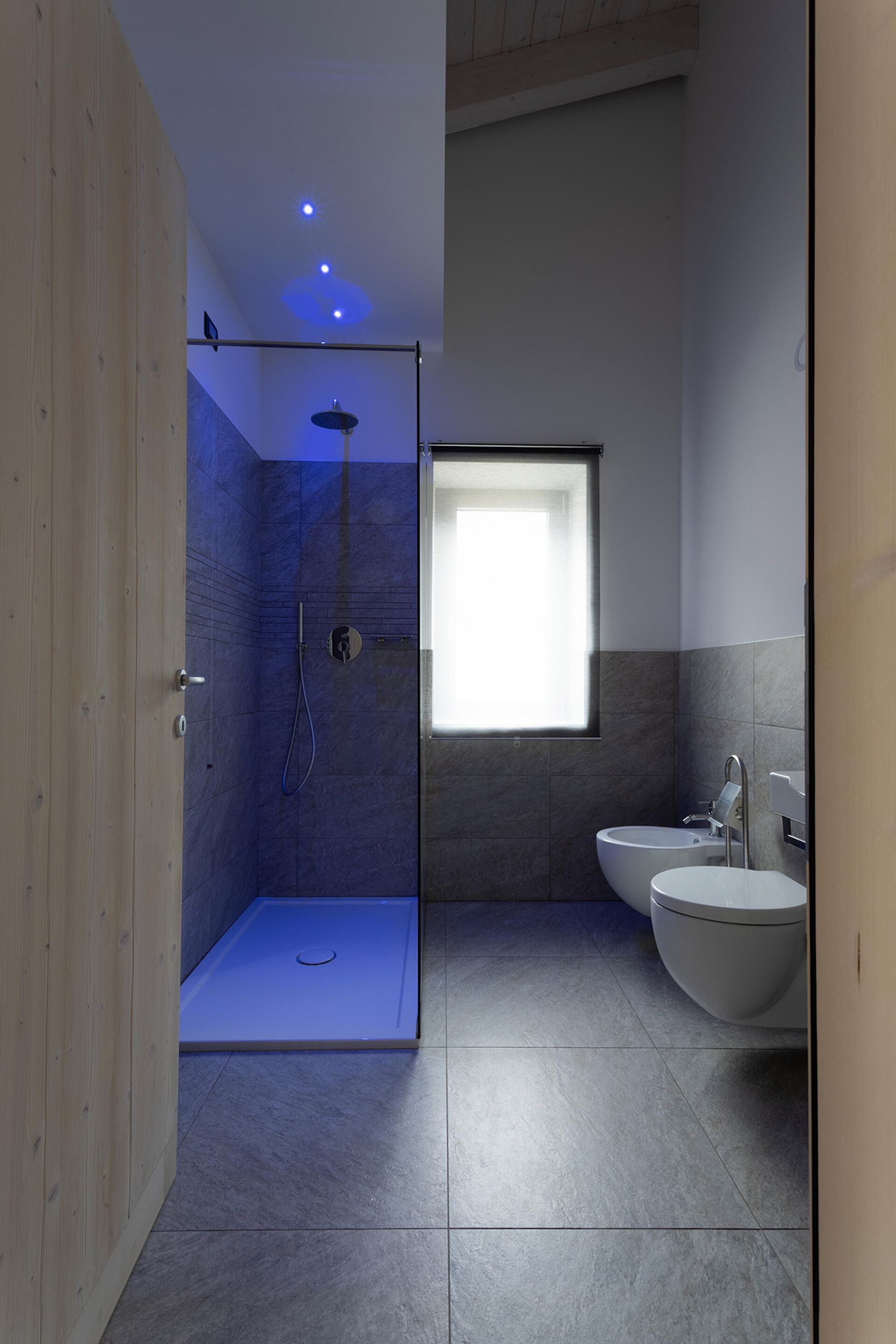 A modern bathroom with a shower, toilet, and sink.