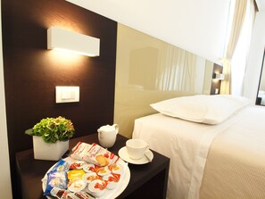 Sengetøy av topp kvalitet, dundyner, minibar og safe på rommet