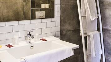 A bathroom with a white sink, mirror, and towel rack.