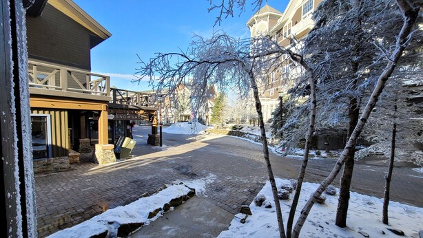 A snow-covered street with buildings, a sign for 'Snowshoe', and bare trees. - TOP FLOOR IN RIMFIRE/VILLAGE! NEVER RENTED BEFORE JULY 2022 2 BEDROOMS SLEEPS 8! (Snowshoe)