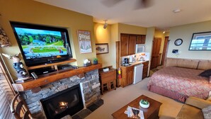 A living room with a fireplace, television, and a cozy seating area. - TOP FLOOR IN RIMFIRE/VILLAGE! NEVER RENTED BEFORE JULY 2022 2 BEDROOMS SLEEPS 8! (Snowshoe)