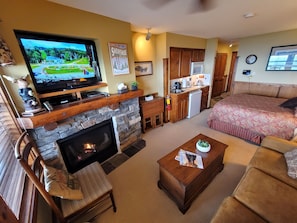 A living room with a fireplace, television, and a cozy seating area. - TOP FLOOR IN RIMFIRE/VILLAGE! NEVER RENTED BEFORE JULY 2022 2 BEDROOMS SLEEPS 8! (Snowshoe)