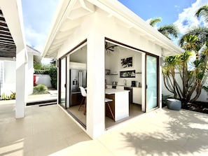 A modern kitchen with a refrigerator, sink, and coffee maker. - Waterfront Zenith Nevis Private Luxury Villa w 3rd, 4th, & 5th Bedroom Option. (Nevis)