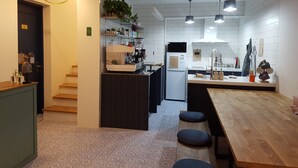 A modern kitchen with a central island, pendant lighting, and a refrigerator. - Hostel Single Single (Busan)