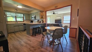 Una cocina con comedor, piso de madera y ventilador de techo.