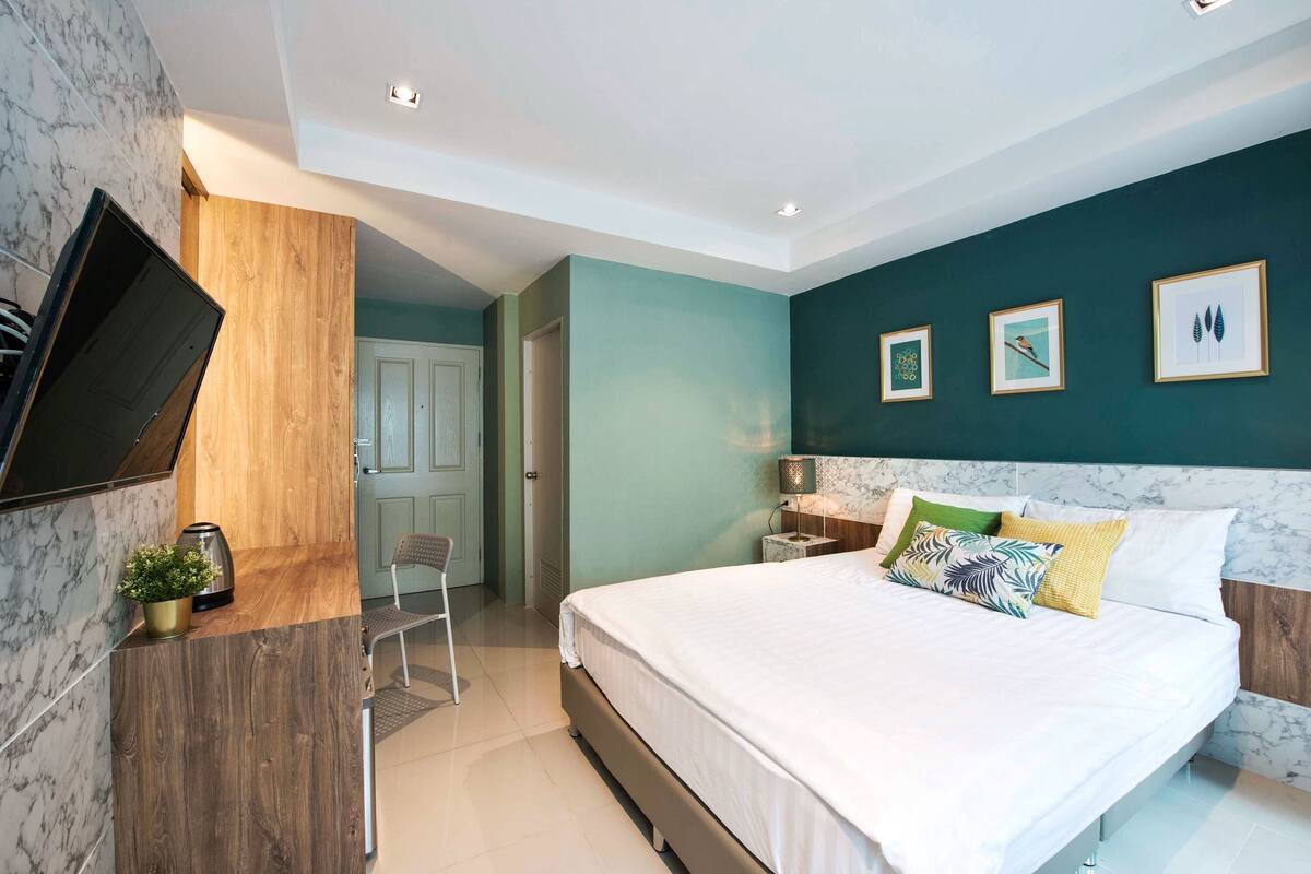 Een moderne slaapkamer met een bed, een bureau en een televisie.