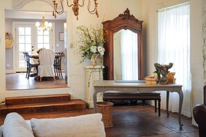 Uma sala de jantar com mesa, cadeiras e lustre.