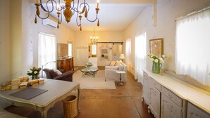 A spacious living room with a chandelier, a sofa, a coffee table, and a cabinet. - Luxury Cottage in Jacksonville's Historic Core! (Jacksonville)